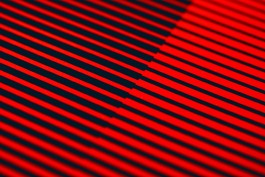 Simplicity closeup. Extreme close-up of Simplicity by Marçal Prats, showing the precision of the screenprinted red horizontal lines against a deep navy blue background. The fine detail highlights slight ink texture and reveals the alignment shift where the linear pattern intersects, enhancing the artwork’s optical tension and layered geometry.