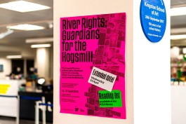 CCD KSA Exhibit Poster Column. Bright pink poster displayed on a gallery wall at Kingston School of Art, promoting River Rights: Guardians for the Hogsmill. Bold black text highlights the event’s message about the Hogsmill River’s intrinsic rights. Overlay stickers announce an extended date (Wednesday 23 April) and a reading list available at the KSA library. The background features a woven river texture in magenta, blending activism with design.