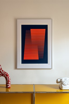 Simplicity framed. artwork by Marçal Prats displayed in a contemporary interior. The screenprint, featuring red horizontal lines on a navy blue background, hangs above a glossy yellow sideboard with a red ceramic sculpture and a white rotary phone. The clean, minimalist setting highlights the geometric precision and bold colour contrast of the print.